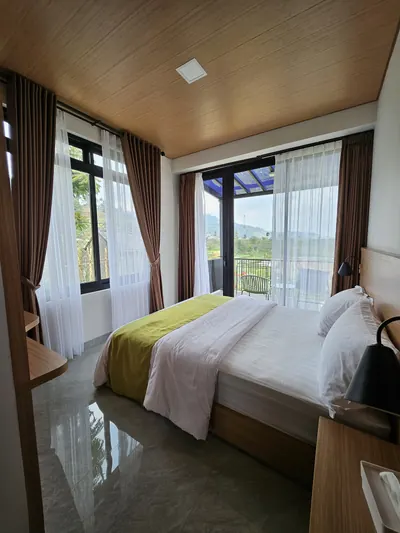 Kamar tidur Del Luna dengan jendela dari lantai ke langit-langit menghadap ladang dan bukit