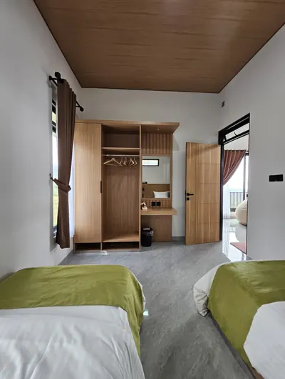 Kamar tidur dua single bed dengan lemari pakaian kayu dan pintu geser