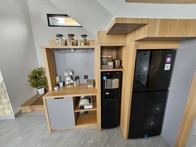 Pantry villa dengan kulkas dua pintu, dispenser air, dan rak kayu